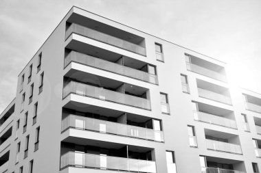 Güneş ışınları kentsel binalar üzerinde ışık etkisi yaratıyor. Düz binaları olan modern bir apartman dairesi. Yeni lüks ev ve kompleksin ayrıntıları. Siyah ve beyaz.