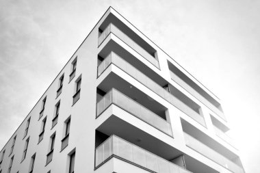 Güneş ışınları kentsel binalar üzerinde ışık etkisi yaratıyor. Düz binaları olan modern bir apartman dairesi. Yeni lüks ev ve kompleksin ayrıntıları. Siyah ve beyaz.