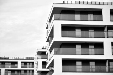 Güneş ışınları kentsel binalar üzerinde ışık etkisi yaratıyor. Düz binaları olan modern bir apartman dairesi. Yeni lüks ev ve kompleksin ayrıntıları. Siyah ve beyaz.