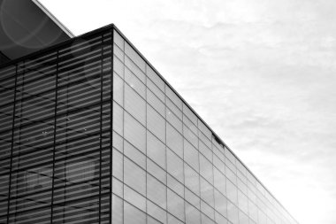 Güneş ışığı günbatımında kentsel binalar üzerinde ışık etkisi yaratır. Modern ofis inşaatı, güneş ışığıyla kaplı cam yüzey. İş geçmişi. Siyah ve beyaz.