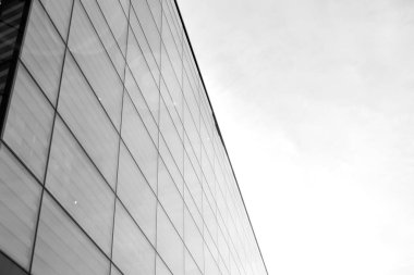 Güneş ışığı günbatımında kentsel binalar üzerinde ışık etkisi yaratır. Modern ofis inşaatı, güneş ışığıyla kaplı cam yüzey. İş geçmişi. Siyah ve beyaz.
