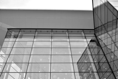 Güneş ışığı günbatımında kentsel binalar üzerinde ışık etkisi yaratır. Modern ofis inşaatı, güneş ışığıyla kaplı cam yüzey. İş geçmişi. Siyah ve beyaz.