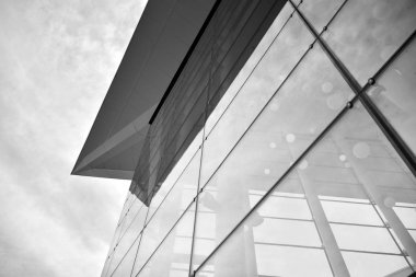 Güneş ışığı günbatımında kentsel binalar üzerinde ışık etkisi yaratır. Modern ofis inşaatı, güneş ışığıyla kaplı cam yüzey. İş geçmişi. Siyah ve beyaz.