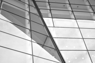 Güneş ışığı günbatımında kentsel binalar üzerinde ışık etkisi yaratır. Modern ofis inşaatı, güneş ışığıyla kaplı cam yüzey. İş geçmişi. Siyah ve beyaz.