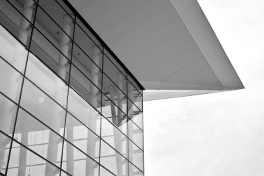 Güneş ışığı günbatımında kentsel binalar üzerinde ışık etkisi yaratır. Modern ofis inşaatı, güneş ışığıyla kaplı cam yüzey. İş geçmişi. Siyah ve beyaz.