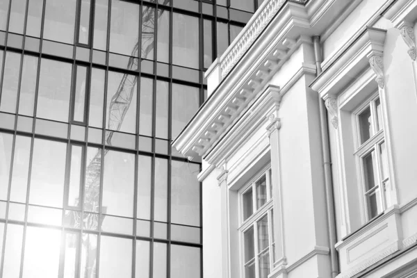 Sun rays light effects on urban buildings in sunset. Modern office building detail, glass surface with sunlight. Business background. Black and white.