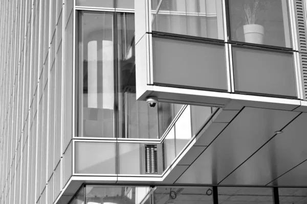 Sun rays light effects on urban buildings in sunset. Modern office building detail, glass surface with sunlight. Business background. Black and white.