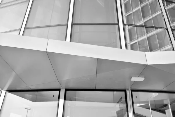 Sun rays light effects on urban buildings in sunset. Modern office building detail, glass surface with sunlight. Business background. Black and white.