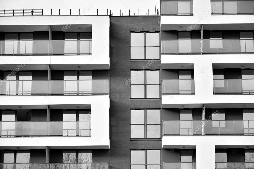 Sun rays light effects on urban buildings. Fragment of modern residential apartment with flat buildings exterior. Detail of new luxury house and home complex. Black and white.