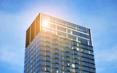  Güneş ışığı günbatımında kentsel binalar üzerinde ışık etkisi yaratır. Modern ofis inşaatı, güneş ışığıyla kaplı cam yüzey. İş geçmişi. 