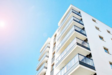 Güneş ışınları kentsel binalar üzerinde ışık etkisi yaratıyor. Düz binaları olan modern bir apartman dairesi. Yeni lüks ev ve ev kompleksinin ayrıntıları. 