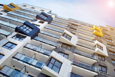 Güneş ışınları kentsel binalar üzerinde ışık etkisi yaratıyor. Düz binaları olan modern bir apartman dairesi. Yeni lüks ev ve ev kompleksinin ayrıntıları. 