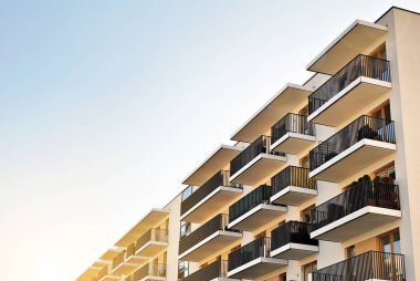 Güneş ışınları kentsel binalar üzerinde ışık etkisi yaratıyor. Düz binaları olan modern bir apartman dairesi. Yeni lüks ev ve ev kompleksinin ayrıntıları. 