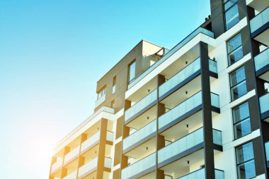 Güneş ışınları kentsel binalar üzerinde ışık etkisi yaratıyor. Düz binaları olan modern bir apartman dairesi. Yeni lüks ev ve ev kompleksinin ayrıntıları. 