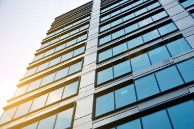 Güneş ışığı günbatımında kentsel binalar üzerinde ışık etkisi yaratır. Modern ofis inşaatı, güneş ışığıyla kaplı cam yüzey. İş geçmişi. 