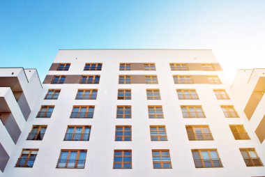 Güneş ışınları kentsel binalar üzerinde ışık etkisi yaratıyor. Düz binaları olan modern bir apartman dairesi. Yeni lüks ev ve ev kompleksinin ayrıntıları. 