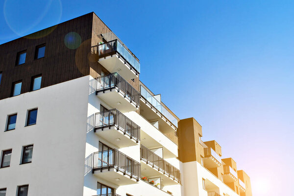 Sun rays light effects on urban buildings. Fragment of modern residential apartment with flat buildings exterior. Detail of new luxury house and home complex. 