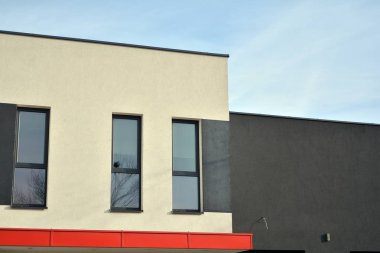 Mavi gökyüzü olan güneşli bir günde modern apartman binaları. Modern bir apartmanın ön cephesi. Güneş ışığıyla kaplı cam yüzey..