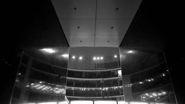 Gece mimarisi - cam cepheli bina. İş bölgesi. Ekonomi kavramı, finans. Dışarıdaki ticari ofis binasının fotoğrafı. Ofis binasının soyut görüntüsü. Siyah ve beyaz.