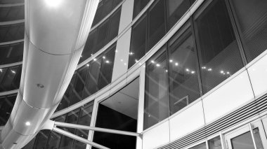 Gece mimarisi - cam cepheli bina. İş bölgesi. Ekonomi kavramı, finans. Dışarıdaki ticari ofis binasının fotoğrafı. Ofis binasının soyut görüntüsü. Siyah ve beyaz.