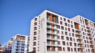 Modern multi story building being lit by the setting sun at afternoon. New apartment house residential building outdoor concept.
