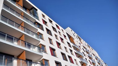 Modern multi story building being lit by the setting sun at afternoon. New apartment house residential building outdoor concept.