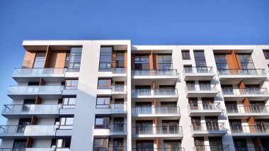 Modern multi story building being lit by the setting sun at afternoon. New apartment house residential building outdoor concept.