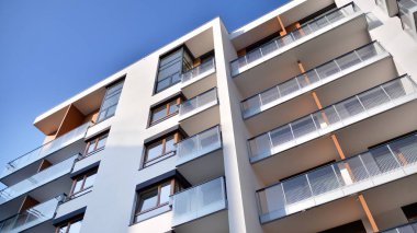 Modern multi story building being lit by the setting sun at afternoon. New apartment house residential building outdoor concept.