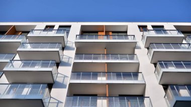 Modern multi story building being lit by the setting sun at afternoon. New apartment house residential building outdoor concept.
