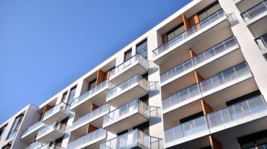 Modern multi story building being lit by the setting sun at afternoon. New apartment house residential building outdoor concept.