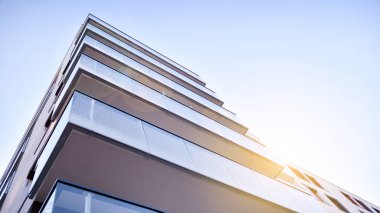 Modern multi story building being lit by the setting sun at afternoon. New apartment house residential building outdoor concept.
