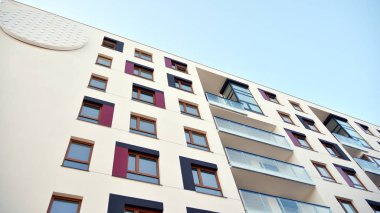 Modern multi story building being lit by the setting sun at afternoon. New apartment house residential building outdoor concept.