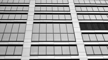 Güneş ışığı günbatımında kentsel binalar üzerinde ışık etkisi yaratır. Modern ofis inşaatı, güneş ışığıyla kaplı cam yüzey. İş geçmişi. Siyah ve beyaz.