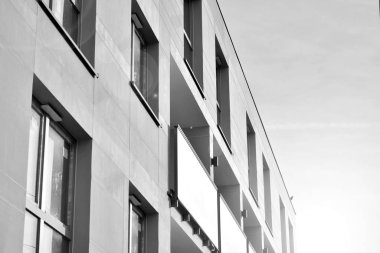 Güneş ışınları kentsel binalar üzerinde ışık etkisi yaratıyor. Düz binaları olan modern bir apartman dairesi. Yeni lüks ev ve kompleksin ayrıntıları. Siyah ve beyaz.
