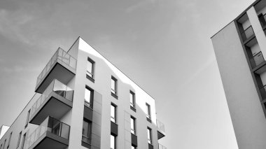 Güneş ışınları kentsel binalar üzerinde ışık etkisi yaratıyor. Düz binaları olan modern bir apartman dairesi. Yeni lüks ev ve kompleksin ayrıntıları. Siyah ve beyaz.