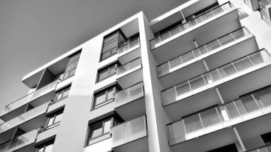 Güneş ışınları kentsel binalar üzerinde ışık etkisi yaratıyor. Düz binaları olan modern bir apartman dairesi. Yeni lüks ev ve kompleksin ayrıntıları. Siyah ve beyaz.