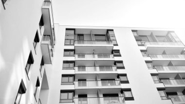 Güneş ışınları kentsel binalar üzerinde ışık etkisi yaratıyor. Düz binaları olan modern bir apartman dairesi. Yeni lüks ev ve kompleksin ayrıntıları. Siyah ve beyaz.