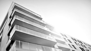 Güneş ışınları kentsel binalar üzerinde ışık etkisi yaratıyor. Düz binaları olan modern bir apartman dairesi. Yeni lüks ev ve kompleksin ayrıntıları. Siyah ve beyaz.