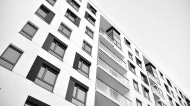 Güneş ışınları kentsel binalar üzerinde ışık etkisi yaratıyor. Düz binaları olan modern bir apartman dairesi. Yeni lüks ev ve kompleksin ayrıntıları. Siyah ve beyaz.