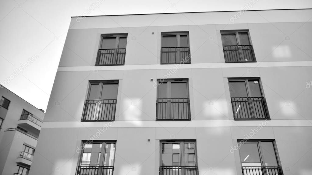 Sun rays light effects on urban buildings. Fragment of modern residential apartment with flat buildings exterior. Detail of new luxury house and home complex. Black and white.