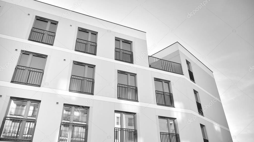 Sun rays light effects on urban buildings. Fragment of modern residential apartment with flat buildings exterior. Detail of new luxury house and home complex. Black and white.