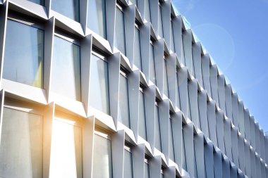 Modern architecture with sun ray. Glass facade on a bright sunny day with sunbeams in the blue sky.