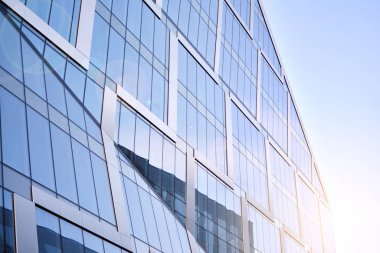 Modern architecture with sun ray. Glass facade on a bright sunny day with sunbeams in the blue sky.