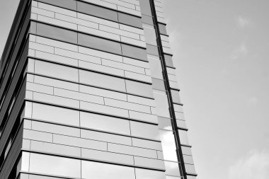 A view at a straight facade of a modern building with a dark grey facade. Dark grey metallic panel facad. Modern architectural details. Black and white.