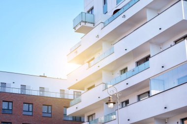 Modern multi story building being lit by the setting sun at afternoon. New apartment house residential building outdoor concept.