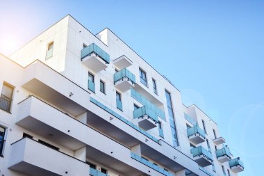 Modern multi story building being lit by the setting sun at afternoon. New apartment house residential building outdoor concept.