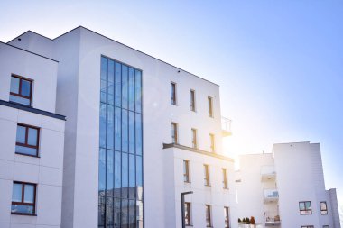 Güneş ışınları kentsel binalar üzerinde ışık etkisi yaratıyor. Düz binaları olan modern bir apartman dairesi. Yeni lüks ev ve ev kompleksinin ayrıntıları. 