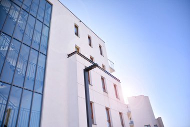 Güneş ışınları kentsel binalar üzerinde ışık etkisi yaratıyor. Düz binaları olan modern bir apartman dairesi. Yeni lüks ev ve ev kompleksinin ayrıntıları. 