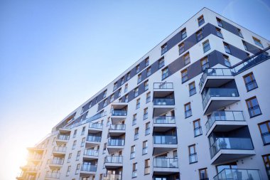 Güneş ışınları kentsel binalar üzerinde ışık etkisi yaratıyor. Düz binaları olan modern bir apartman dairesi. Yeni lüks ev ve ev kompleksinin ayrıntıları. 