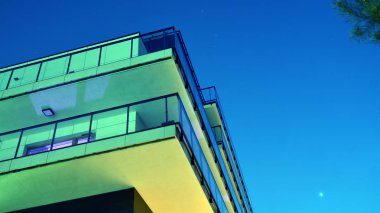 House building and city construction concept: evening outdoor urban view of modern real estate homes. View of balconies of apartment building at night.